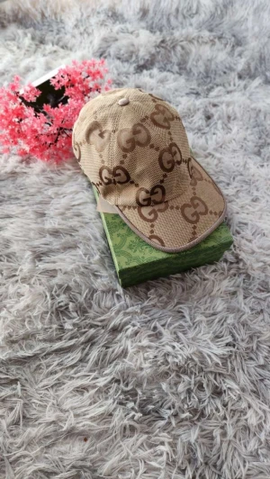 Beige keps med GG-mönster - Säljer en beige keps  med det klassiska GG-logomönstret i brunt. Kepsen har böjd skärm och är tillverkad i ett slitstarkt bomullsmaterial. Perfekt accessoar för att lyfta din outfit med en lyxig touch.