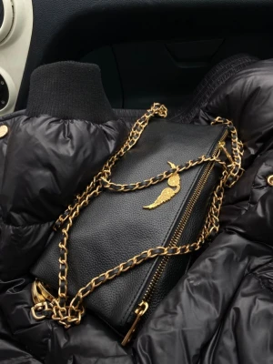Svart zadig&volyaire väska med guldkedja - Stilren svart axelväska i skinn med grov guldfärgad kedja och dragkedja. Väskan har en snygg guldfärgad detalj med vinge på framsidan som ger en lyxig känsla. Perfekt för dig som vill ha en trendig och elegant accessoar. Oäkta
