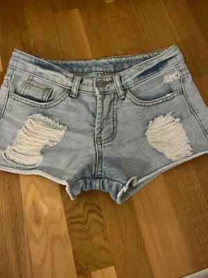 Ljusblå denimshorts med slitningar - Lågmidjade korta jeansshorts. Fint skick. Pris går att diskutera! 💘