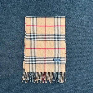 Burberry scarf - Burberry-scarf som är 100% äkta. Mindre defekter kan förekomma enligt bild men inget märkvärdigt då de är vintage. Snabb leverans och trygg handel då vi har 7 års erfarenhet i branschen. Vid frågor eller bud, skicka gärna ett meddelande. 1019