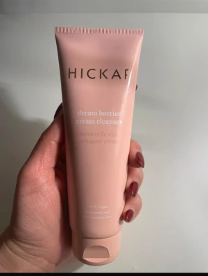 Hickap Dream Barrier Cream Cleanser - Rosa tub med Hickap Dream Barrier Cream Cleanser, en vegansk ansiktsrengöring för normal, torr och känslig hud. Tuben är stilren och har en mjuk, krämig formula som rengör huden skonsamt. Perfekt för dig som vill ha en mild och effektiv rengöring.