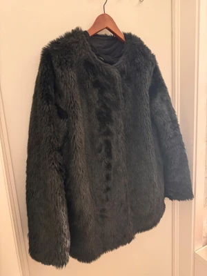 Svart pälsjacka med lång ärm, Rut& Cirkle  - Säljer en svart pälsjacka med lång ärm och rund hals. Jackan har en fluffig och mjuk yta som ger en cool och trendig look. Perfekt för dig som vill ha en varm och snygg jacka med lite extra attityd. Passar dig som gillar statement-plagg. Priset går alltid att diskutera.