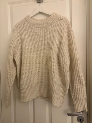 Krämfärgad stickad tröja från 157 - Säljer en krämfärgad stickad tröja från 157 i storlek S. Tröjan har en grovstickad struktur, rund hals och långa ärmar. Perfekt för dig som gillar en enkel och chill stil med lite oversized känsla. 