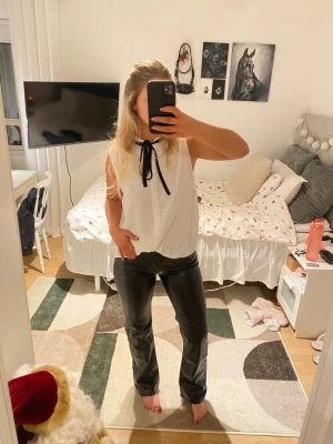 Svarta bootcut byxor i skinnimitation - Snygga svarta byxor i skinnimitation med bootcut. Aldrig använda. Låg midja.