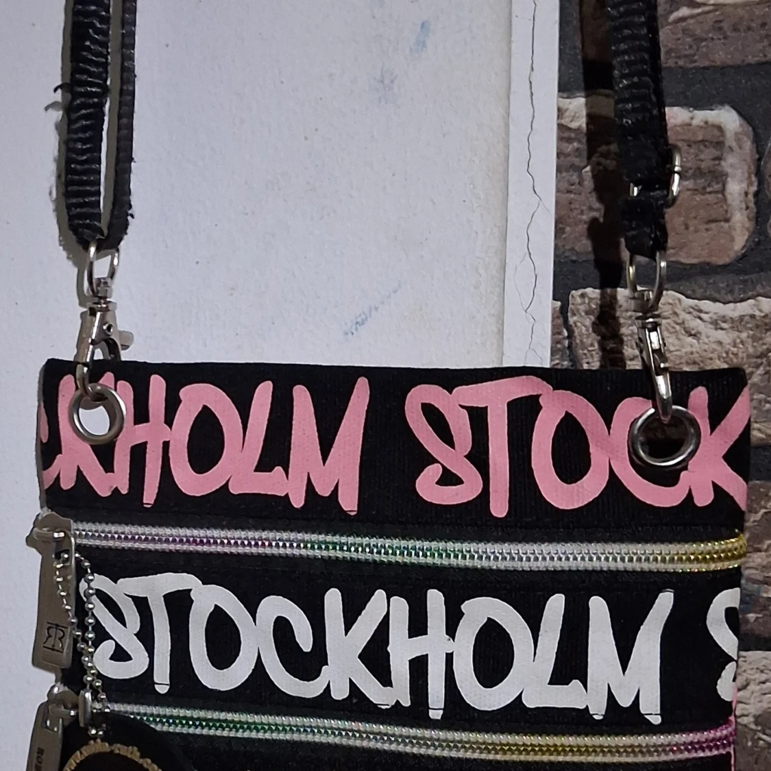 Svart axelväska med rosa text- Robin Ruth 