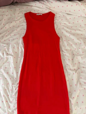 Röd ärmlös klänning från Zara -  röd klänning från Zara i en enkel och tight modell. Klänningen är ärmlös med rund halsringning och har en kort längd. Materialet är mjukt och stretchigt.