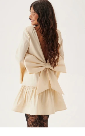  klänning med rosett - Supersöt  klänning från Bubbleroom. Har en djup rygg med stor rosett.  Perfekt som julklänning, helt ny med alla lappar kvar! Slut i storlek på hemsidan. (Nypris 799:-)