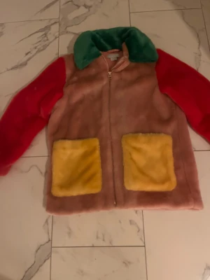 Färgglad teddyjacka med dragkedja - Fuskpäls i storlek 10år. Använd vid ngt enstaka tillfällen och därför i toppskick.