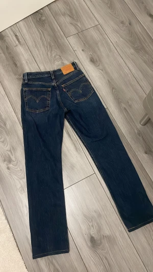 Levi's 501 mörkblå jeans straight fit - Säljer ett par klassiska Levi's 501 jeans i mörkblå tvätt med raka ben och knappgylf. Passar perfekt i längd för mig som är 159/160 cm. 99% cotton & 1% elestan (stretch) 