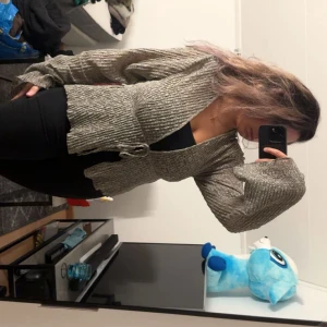 Grön omlottkofta med knyt och spets - Supersnygg grön omlottkofta från med v-ringning, långa vida ärmar och knyt i midjan. Koftan har ett diskret spetsmönster och är tillverkad i ett lätt, stretchigt material som ger en cool och trendig look.