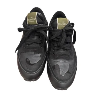 Valentino Rockrunner - Svarta Valentino Garavani sneakers med coolt kamouflagemönster på ovansidan och gröna detaljer på plösen. Snygga nitar på hälen och robust gummisula. Materialmix av skinn och mocka, med snörning och rund tå. Väldigt bra skick förutom dom små markerna man ser på sista bilden 