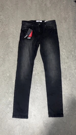 Svarta skinny jeans från FSBN, 30/32 - Svarta skinny jeans från FSBN i storlek 30/32. Snyggt tvättade med mörkgrå ton och klassisk femficksdesign. Jeansen har smal passform och är tillverkade i stretchigt jeansmaterial för extra komfort. Perfekt för dig som gillar en tajt siluett.