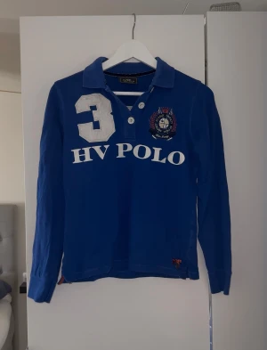 HV polo tröja - Blå långärmad pikétröja i storlek S ifrån HV POLO. Logga fram och bak. Väldigt fint skick, inga defekter 💙