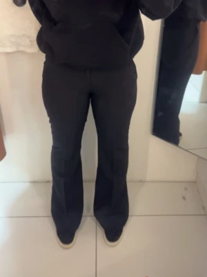 Svarta flare kostymbyxor - Säljer ett par svarta kostymbyxor I flare/bootcut. Byxorna är lågmidjade och har fickor på sidorna, och en ficka där bak!! Byxorna är från Gina Tricot i storlek 34!