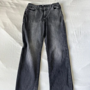 Grå jeans från Jack & Jones - Snygga grå jeans från Jack & Jones med klassisk femficksdesign och raka ben. Jeansen har en cool tvättad look och normal passform. Perfekta för dig som gillar en avslappnad stil med lite edge.