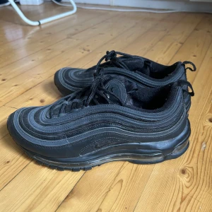Nike Air Max 97 - Säljer ett par Nike Air Max 97 sneakers. Svarta med reflexdetaljer. Använda endast en gång. Nypris 2400kr