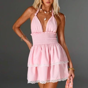 Rosa kort klänning med spetsdetaljer - Supersöt rosa kort klänning med halterneck och smockad midja.  (Från SHEIN)