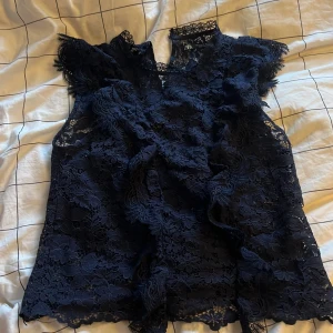 Marinblå spetsblus från Zara - Säljer en superfin marinblå spetsblus från Zara. Blusen har vackra spetsdetaljer. Perfekt för att lyfta vilken outfit som helst. Säljer då den är för liten för mig💞 