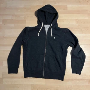Marinblå hoodie från Polo Ralph Lauren - Ralphlauren zip up hoodie i mycket bra skick. Priset kan diskuteras. Kan passa S, dragkedjan är lite sönder