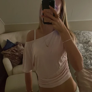 Ljusrosa offshoulder topp - Säljer en ljusrosa topp med offshoulder-design och lös passform. Toppen är croppad och har korta ärmar. Materialet känns mjukt och skönt mot huden💞