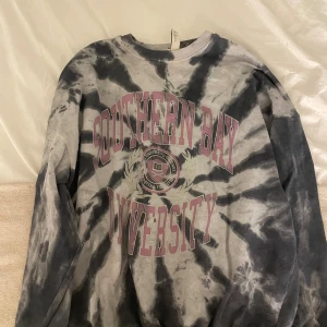 Tie-dye college tröja från Pull&Bear - Säljer en oversized tie-dye tröja från Pull&Bear med coolt svart och grått mönster och tryck i lila och vitt med texten 'Southern Bay university’💗