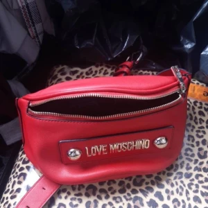 Röd axelväska från Love Moschino - Snygg röd axelväska från Love Moschino.  Väskan är i Perfekt och nyskick, vid snabb affär pris kan diskuteras ⭐️