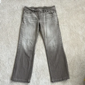 Grå/grå-beigea jeans med raka ben - Snygga grå jeans med raka ben. Jeansen har en lätt tvättad look och normal passform. Snygga knappar uppe vid midjan. Står ingen storlek i dem men passar mig bra som vanligtvis har M.