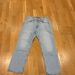 Ljusblå relaxed fit jeans från Dressmann - Säljer ett par ljusblå jeans från Dressmann i relaxed fit. Jeansen har klassisk femficksdesign, raka ben och normal midja. Tillverkade i mjukt denimtyg som ger en skön och avslappnad känsla. Perfekta för dig som gillar en lite lösare passform.