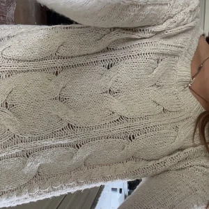 Beige stickad tröja från Hollister - Säljer en beige stickad tröja från Hollister i storlek M. Tröjan har grov kabelstickning, rund halsringning och långa ärmar. Perfekt för lager-på-lager och chill höst- eller vinterstil. Supermjuk och mysig att ha på sig!