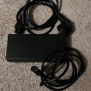 Modiary Li-ion Battery Charger MDA10129402000 - Modiary Li-ion batteriladdare, modell MDA10129402000. Input: 100-240V, 1.8A, Output: 29.4V 2.0A. Säker och pålitlig, med indikator för laddning. Komplett med strömkabel, i gott skick utan synliga defekter eller slitage.