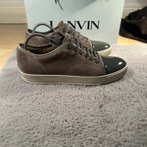Lanvin Patent Cap Toe - Säljer nu mina lanvins i färgen Elephant Grey. Väldigt sparsamt använda, glansen/cap toen är i top skick! Ingår box och dust bag. Storlek 43 men sitter som 44. Tveka inte på att höra av dig!