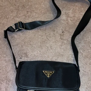 Svart axelväska från Prada i nylon - Helt ny väska av hög kvalitet säljes. Bästa replikan som går att hitta! Kan både mötas upp och skickas.