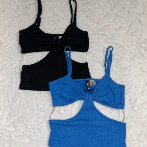 2 st cut out crop tops Divided XS - Två snygga crop tops från Divided i storlek XS, en svart och en blå. Båda har smala axelband, cut out-detalj framtill och är ribbade i materialet. Skön material och superbekväma. Båda säljs tillsammans! Skriv vid frågor 🥰
