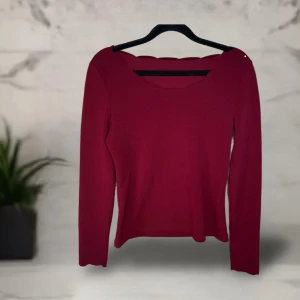 Vinröd långärmad topp från SHEIN - Vinröd långärmad topp från SHEIN i storlek S. Toppen har en unik vågig kant vid halsringningen som ger en snygg detalj. Modellen är figurnära och enkel. Tunt material.