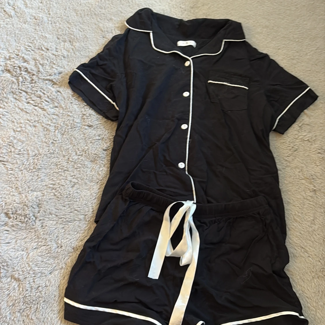 Svart pyjamas med vit snörning