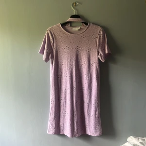 Ljuslila kortklänning från Vila i storleken XS💕 - Supersöt ljuslila kortklänning från Vila i storlek XS. Klänningen har broderade detaljer och korta ärmar, samt medföljande knytband. 💕