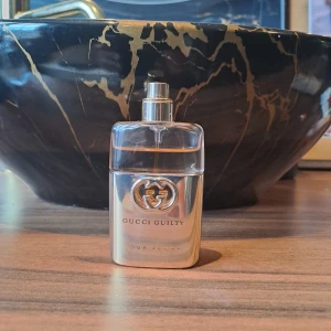 Gucci Guilty Pour Femme parfym - Gucci Guilty Pour Femme parfym i en lyxig, rektangulär flaska med silvrig metall och glas. Flaskan har Guccis ikoniska GG-logga framtill och en stilren spraytopp. Doften är feminin och elegant, perfekt för dig som gillar exklusiva parfymer. Jag har tyvärr tappat locket samt förpackning. Det är 30 ml flaska. Självklart äkta.