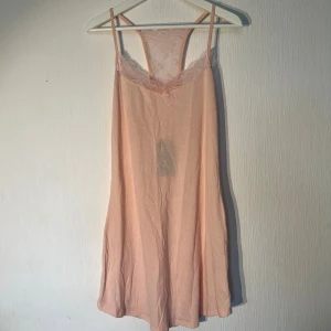 Ljusrosa nattlinne från Lindex - Supersöt ljusrosa nattlinne från Lindex med tunna axelband och v-ringad spets upptill. I storlek M. Ny med prislapp 