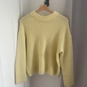 Ljusgul stickad tröja Gina Tricot - Supermysig ljusgul stickad tröja från Gina Tricot. Tröjan har en relaxed fit med bred ribbad kant vid hals, ärmslut och nederkant. Perfekt för lager-på-lager och ger en fräsch vibe till din outfit.