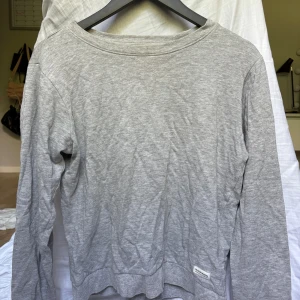 Grå sweatshirt  - En enkel och stilren grå sweatshirt från 157 i storlek 160 men det är som en Xs. Tröjan har rund hals, ribbade muddar vid ärmslut och nederkant samt en liten patch med varumärket nedtill. Perfekt för chill dagar och passar till allt. Mjuk bomullskänsla och långärmad modell. Inga defekter!! Kontakta mig om du har några funderingar!!❤️