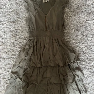 Grön klänning - Snygg grön klänning från twist & tango med volanger och dragkedja framtill💕