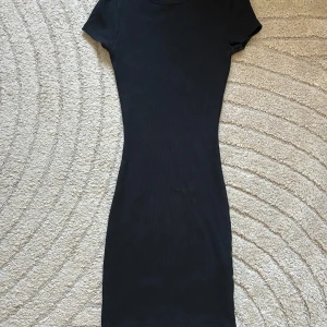 Svart tight klänning - Snygg svart klänning. Kort modell som sitter tight på kroppen, perfekt för fest, utekvällar eller att styla med en oversize jacka för en trendig look 🖤