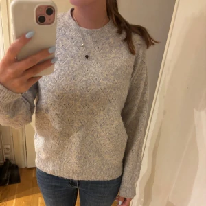 Stickad tröja - Supermysig stickad tröja från Saint Tropez med diskret mönster och rund hals. Tröjan har långa ärmar och ribbade muddar vid ärmslut och nederkant. Flerfärgad.