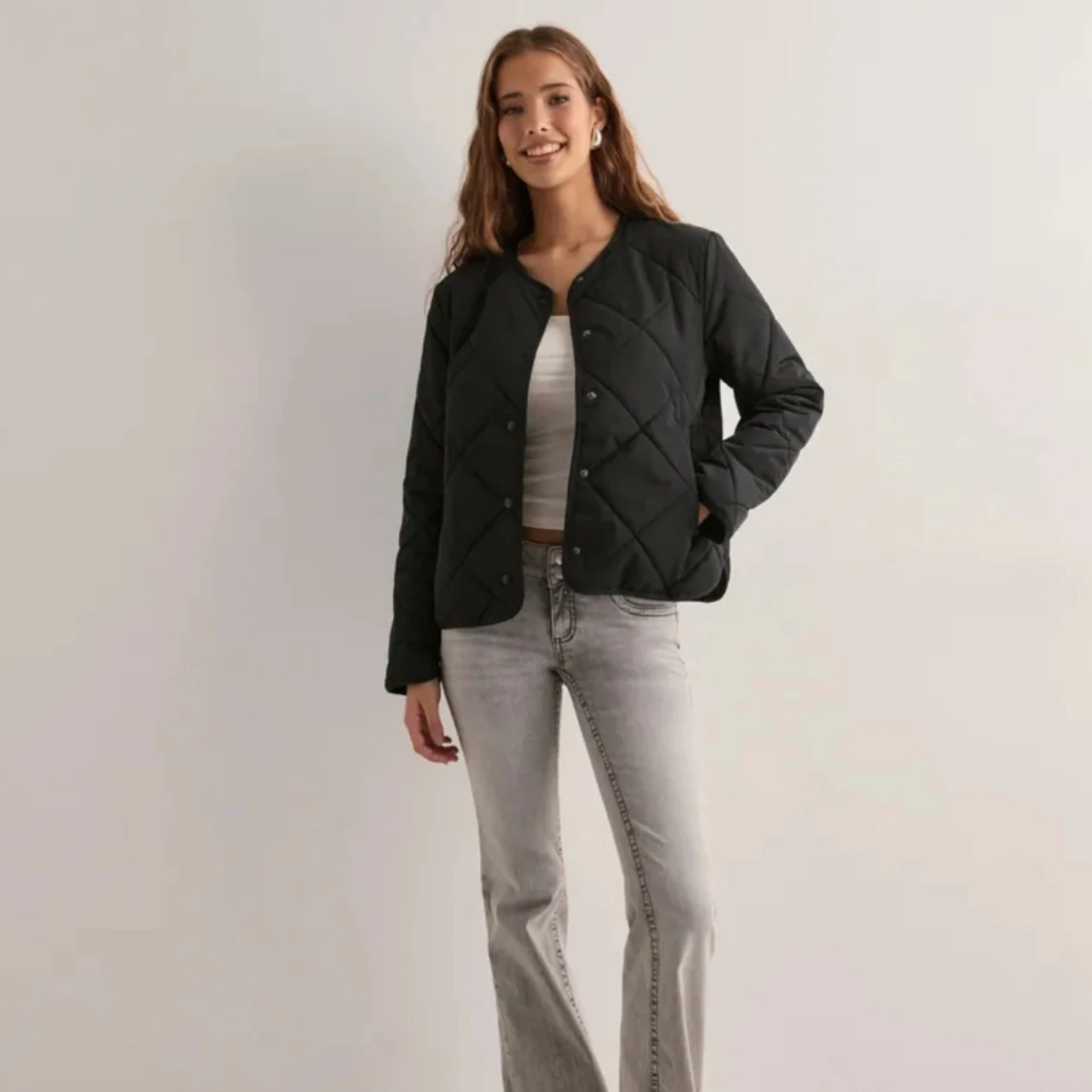 Svart quiltad jacka med tryckknappar