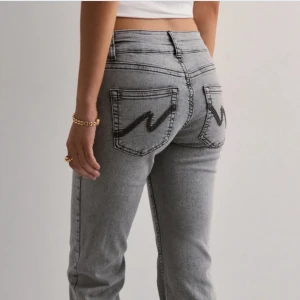 Grå jeans med broderade bakfickor - Snygga grå jeans med svart broderad detalj på bakfickorna. Modellen har låg midja och raka ben med klassisk femficksdesign. Jeansen är från Nelly i storlek 34/xs🫶💕