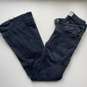 Svarta Bootcut Lee jeans - Snygga svarta jeans från Lee med klassisk femficksdesign och butcutben. Jeansen har normal passform och är tillverkade i mjukt denimtyg. Storlek W27 L33. De är uppsydda men det är lätt att bara spretya upp. De har även hål på insidan av låren som man ser på 4:e bilden. Skriv om ni har frågor!!🖤