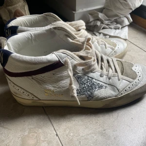 Golden Goose Midstar sneakers med glitter - Golden Goose Midstar sneakers i vitt skinn med beige mockadetaljer, glittrig silverstjärna på sidan och mörkblå samt vinröda detaljer. Äkta,  har tyvärr inte kvar boxen till skorna