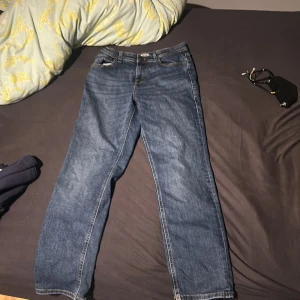 Blå jeans Jack & Jones Regular Clark - Säljer ett par klassiska blå jeans från Jack & Jones, modell Regular Clark. Jeansen har rak passform, normal midja och snygga kontrastsömmar. Perfekta för dig som gillar en tidlös look och vill ha ett par bekväma jeans.