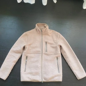 John Henric fleecejacka - Biege fleecejacka från John Henric i toppskick. Varan är knappast använd och har inga repor eller något som är trasigt. Säljs pågrund av att den intr har använts! Storleken är xs men passar S.