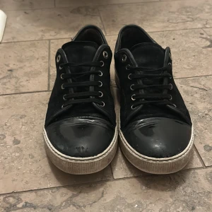 Svarta lanvins captoe med glans  - Säljer ett par svarta lanvins captoe lite slitet på ens sidan på glansen men ser jättebra ut dem är inte använda mycket alls och inga skador på dem 